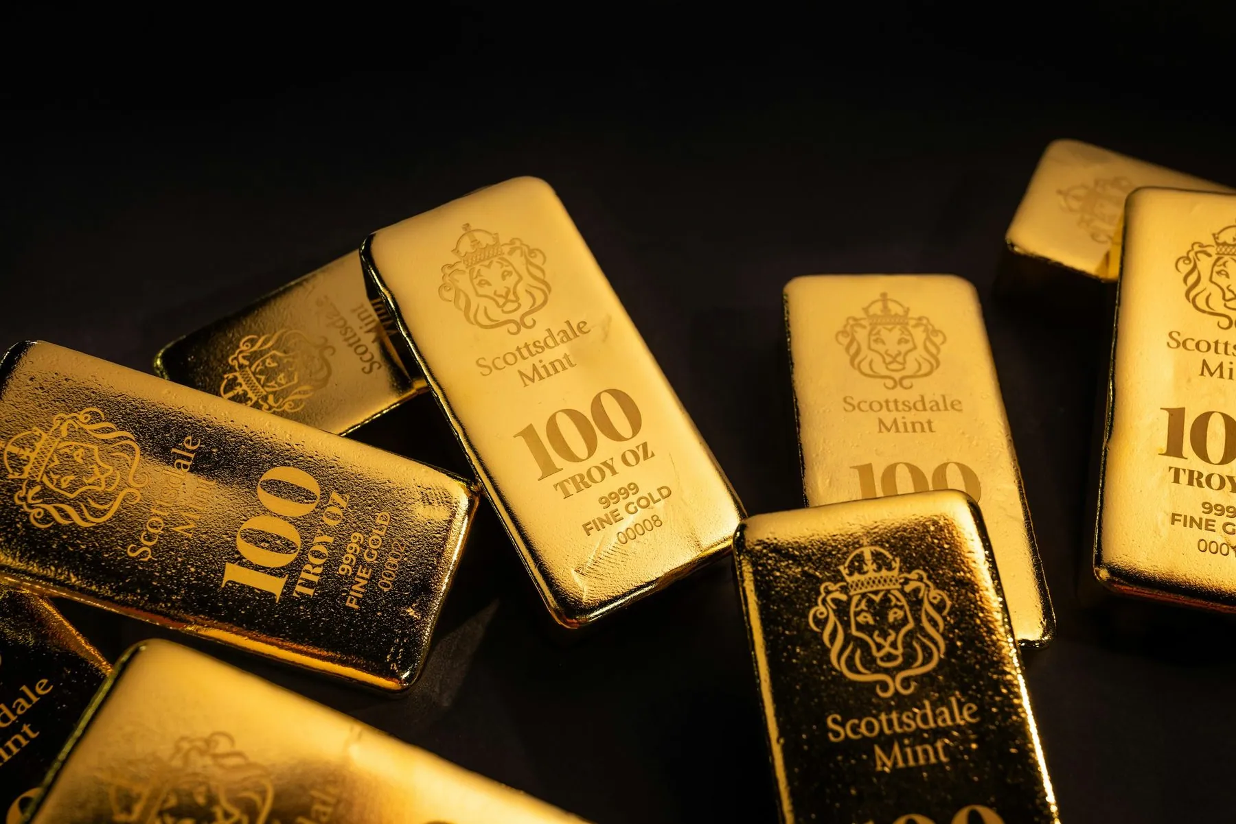 Beautiful 100 Troy Ounce Gold Bullion Bar by Scottsdale Mint sitting on a dark background. Please give a shoutout to Sco