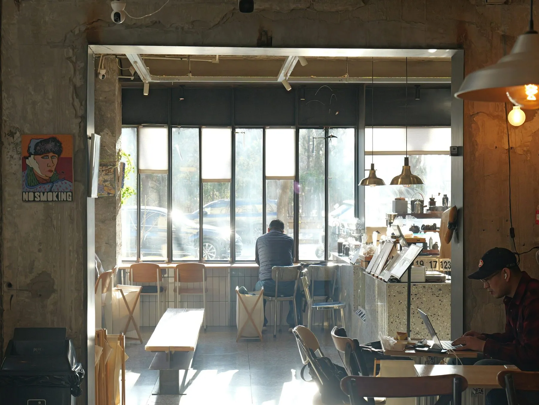 Man working on laptop in a sunlit cafe