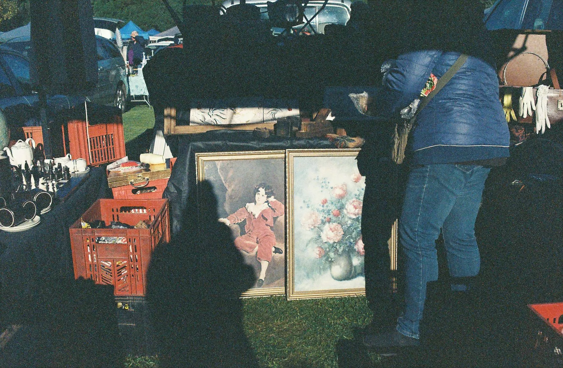 Outdoor market stall with paintings and various merchandise