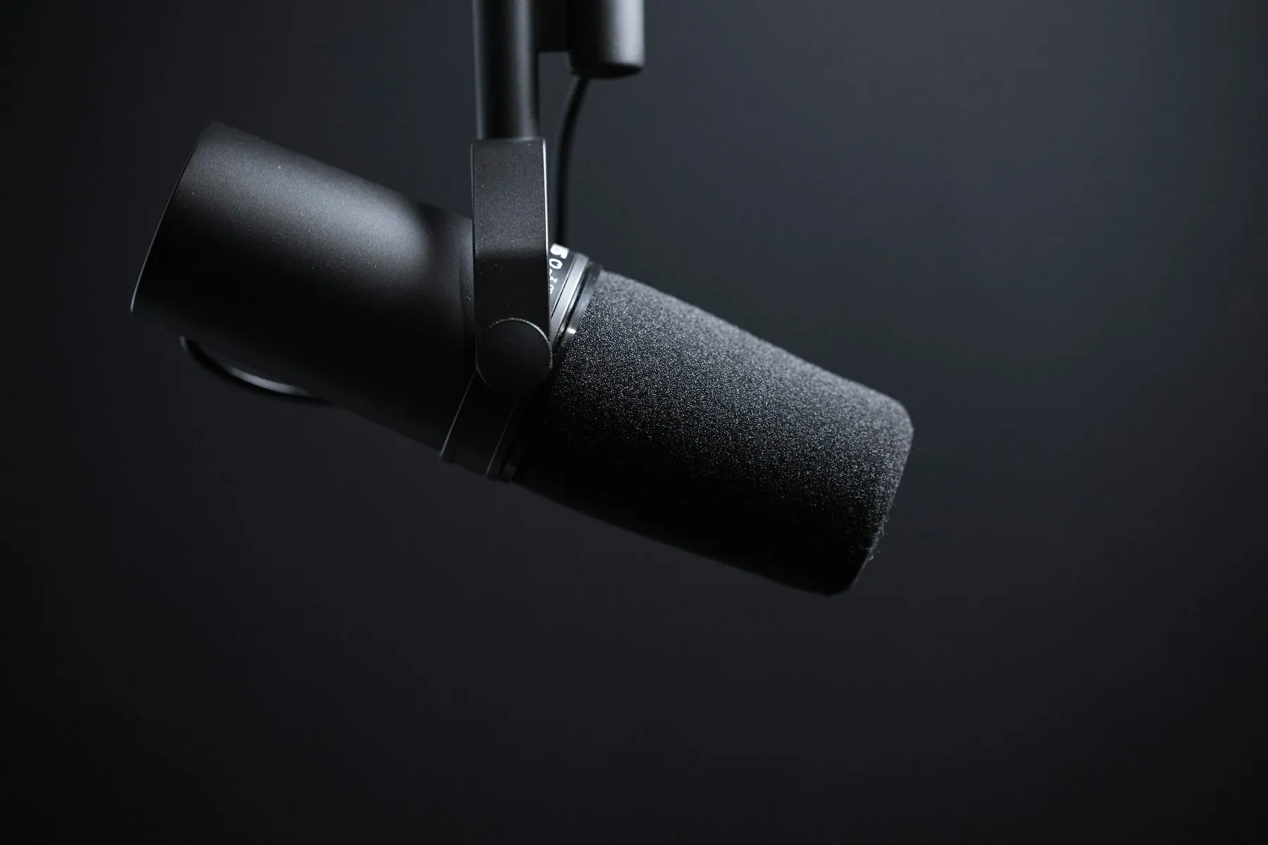 Dynamic podcasting microphone on black. Please consider crediting "Image: Jukka Aalho / Kertojan ääni" and linking to ht