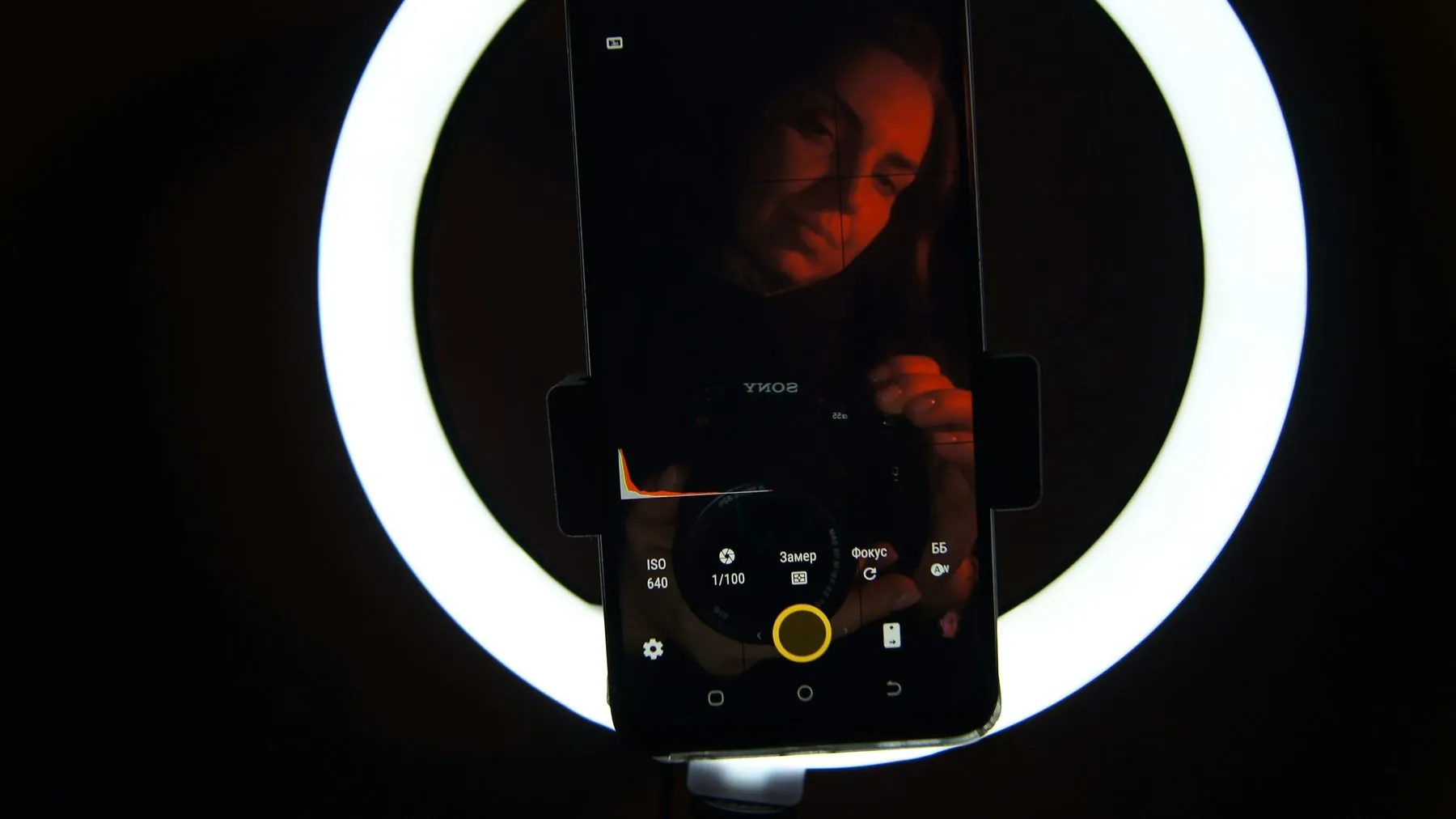 A cell phone sitting in front of a circular light