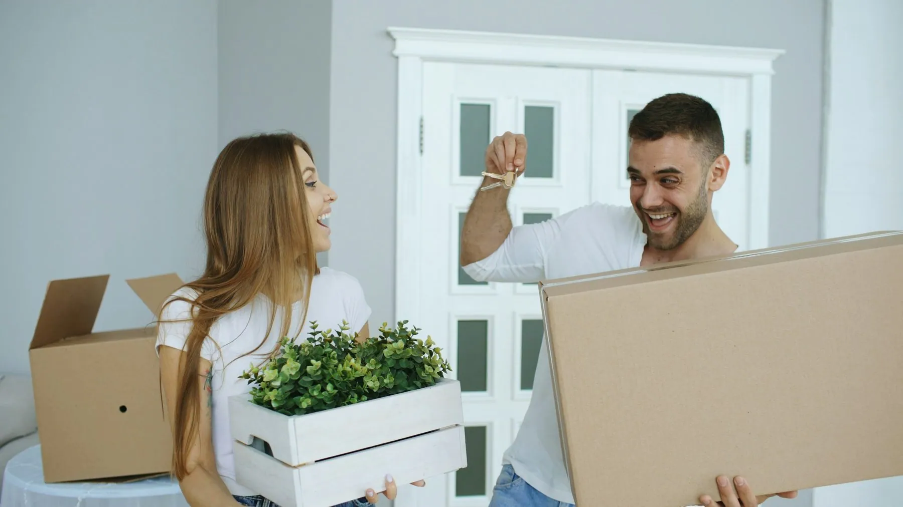 Happy couple watching their new home excited. Young man give keys from house to his girlfriend and kissing her
