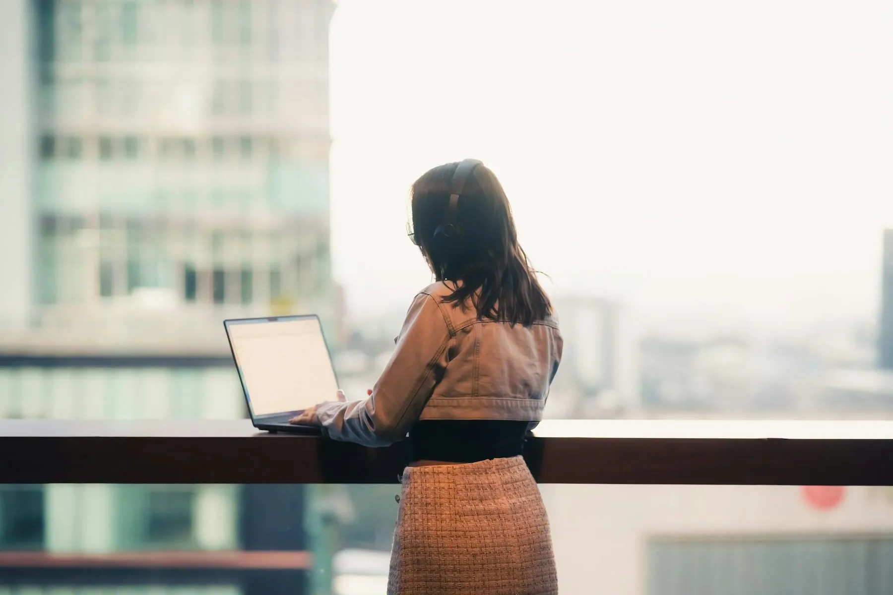 Woman working on laptop with city view